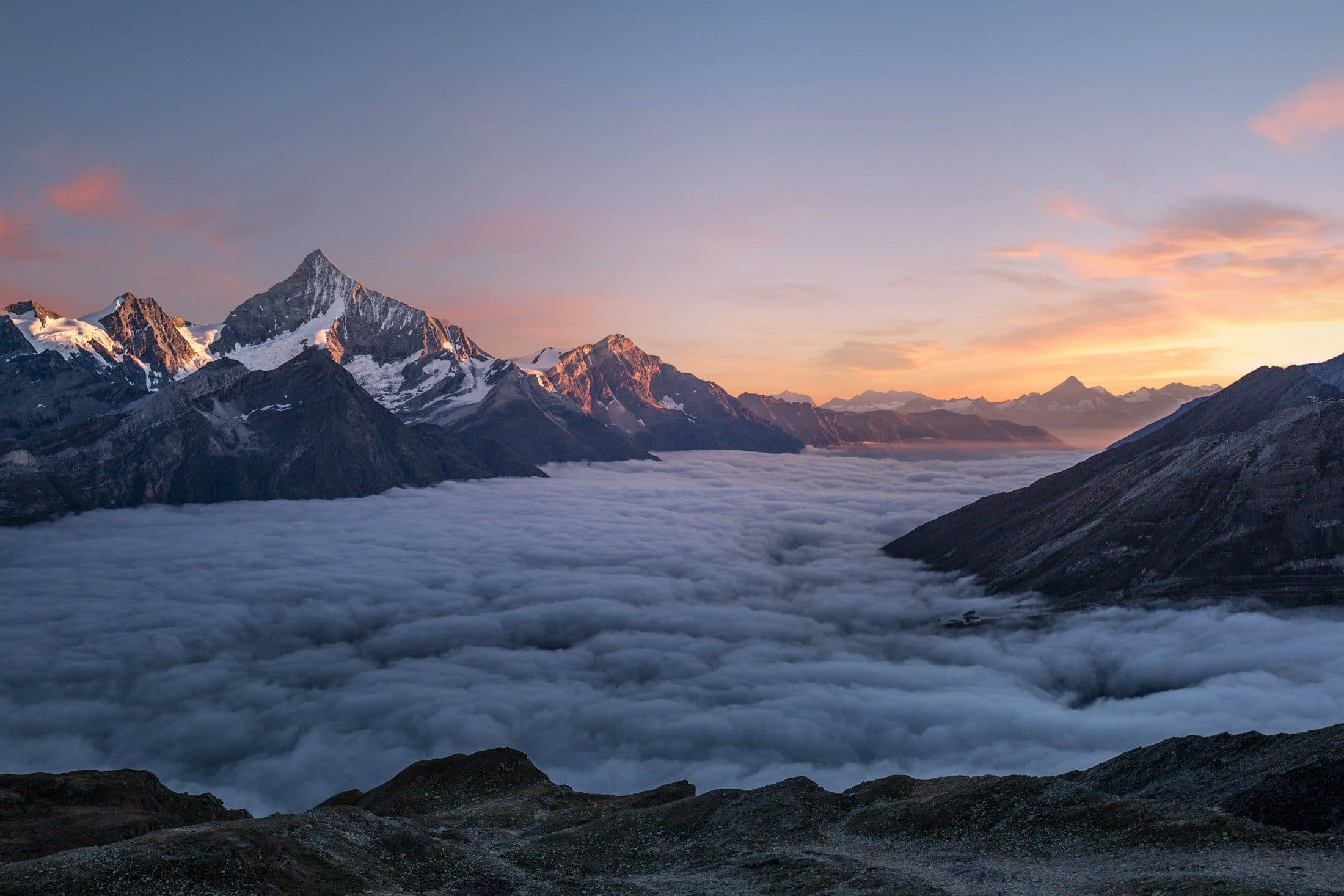 Mountain peaks rising above a sea of cloud at sunrise